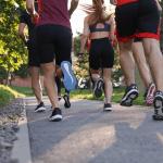 Group of people running outdoors, back view